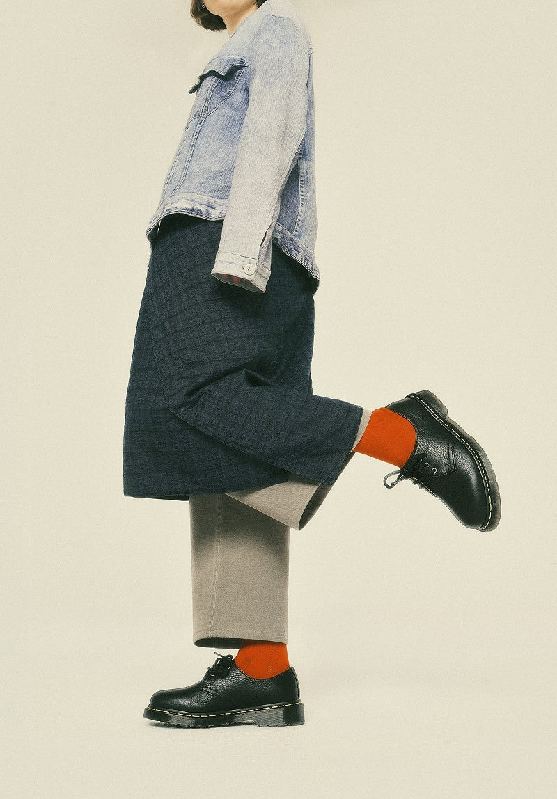 Zapatos de cordones de cuero negro con costura amarilla, con calcetines naranja
